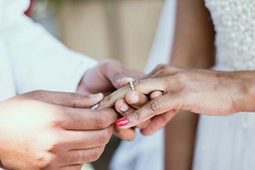 holding hands person putting ring on ring finger of woman wedding